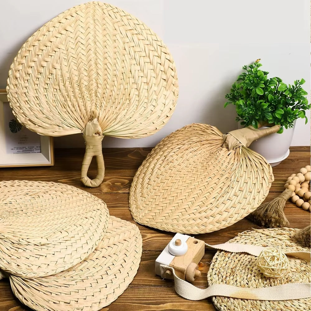 Heart shaped woven hand fans with loop handles set on chairs for a garden wedding