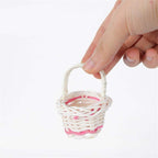 Tiny handwoven basket with handle held between fingers