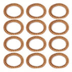 Set of twelve hand woven rattan napkin rings in a warm honey tone