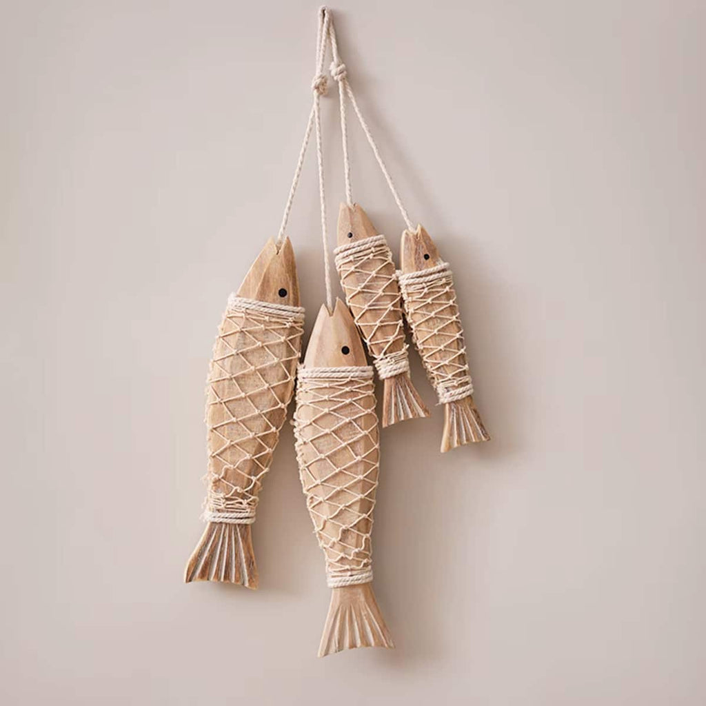 Carved wood fish wrapped in natural rope hanging on a wall