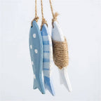 Three painted wood fish hanging together on a twine cord