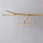 Kids' clothes hanger hand woven in natural rattan in a simple shape