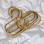 Kids' clothes hanger hand woven in natural rattan in a simple shape