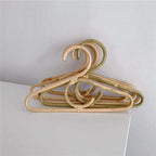 Kids' clothes hanger hand woven in natural rattan in a simple shape