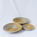 Three round woven wall baskets in natural and yellow tones