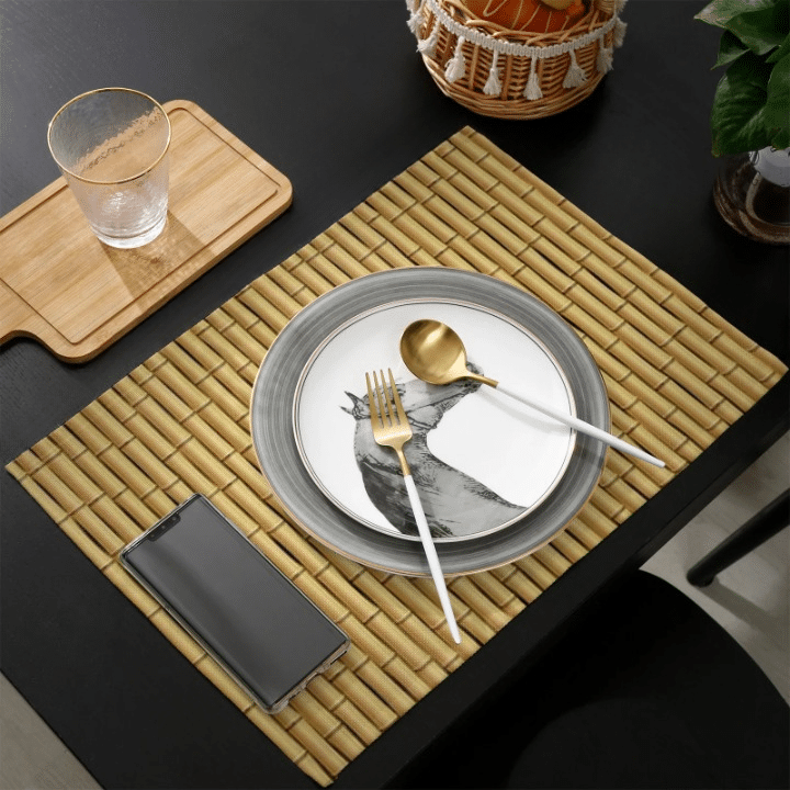 Four beige placemats with a woven bamboo look and interlaced patterns