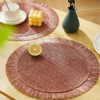 Four round pastoral placemats in woven paper with a straw look, pink or green
