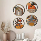 Four round layered wood wall art pieces with boho sun and leaf designs
