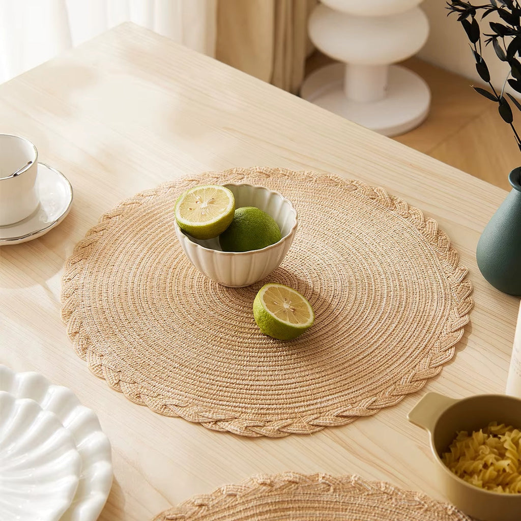Four round beige placemats with a tight spiral straw look weave