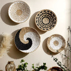 Four round woven wall baskets in natural, black and white patterns