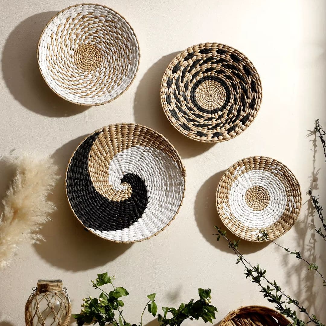 Four round woven wall baskets in natural, black and white patterns