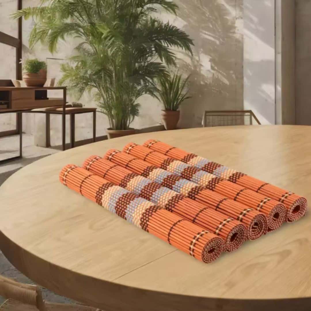 Five boho woven bamboo placemats in a warm orange tone