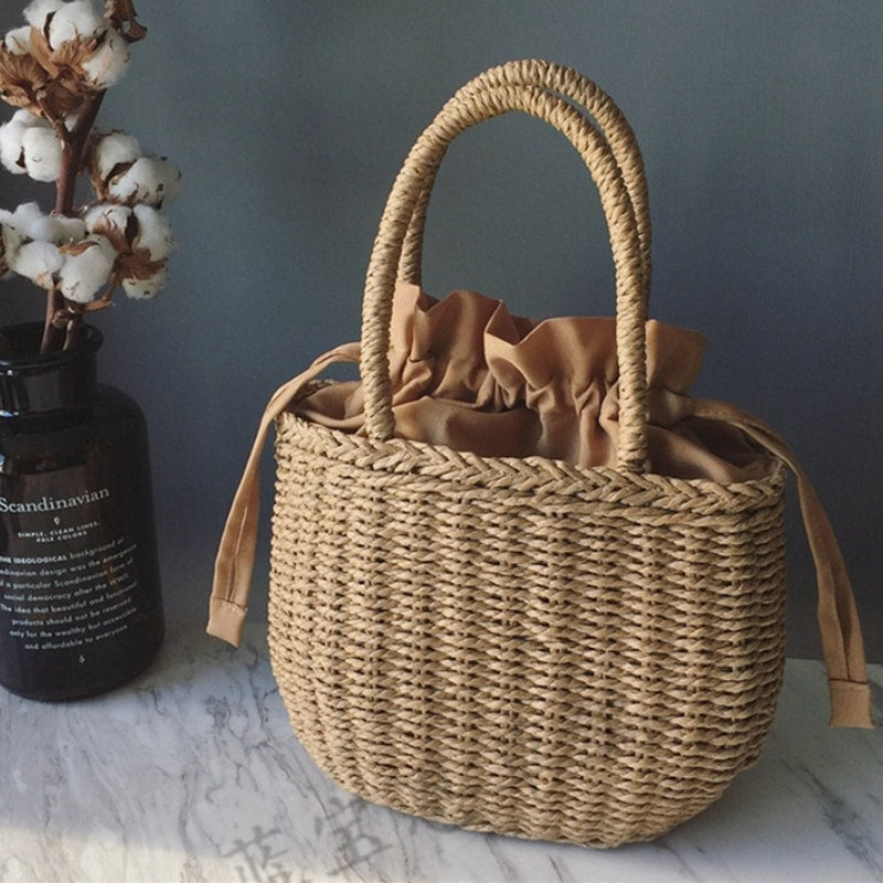 Small structured hand woven rattan handbag with warm natural highlights