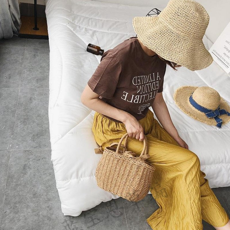 Small structured hand woven rattan handbag with warm natural highlights