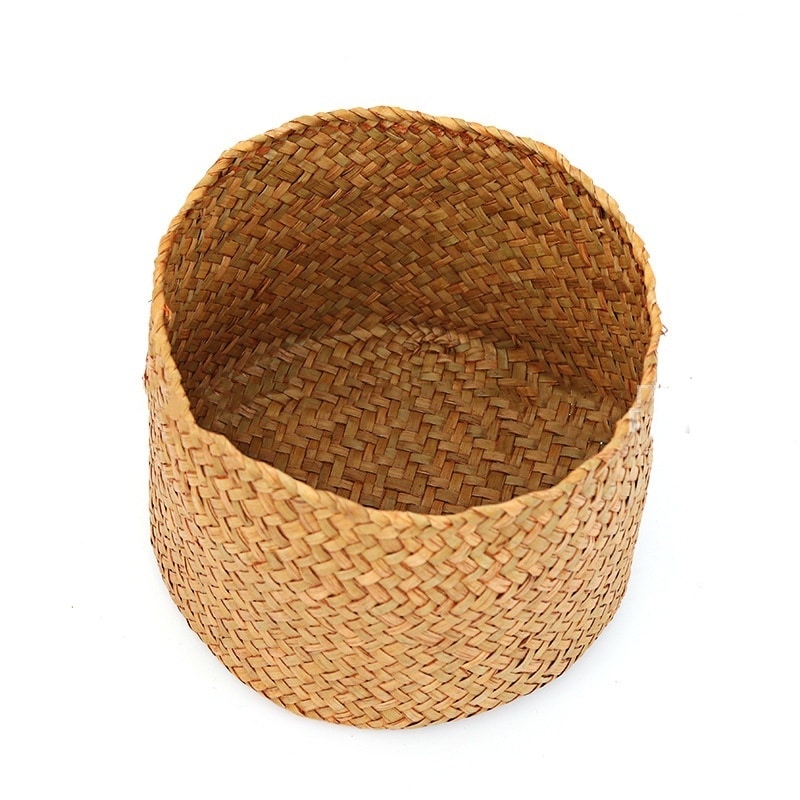 Small round woven straw basket with lid holding cosmetics