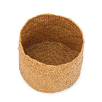 Small round woven straw basket with lid holding cosmetics