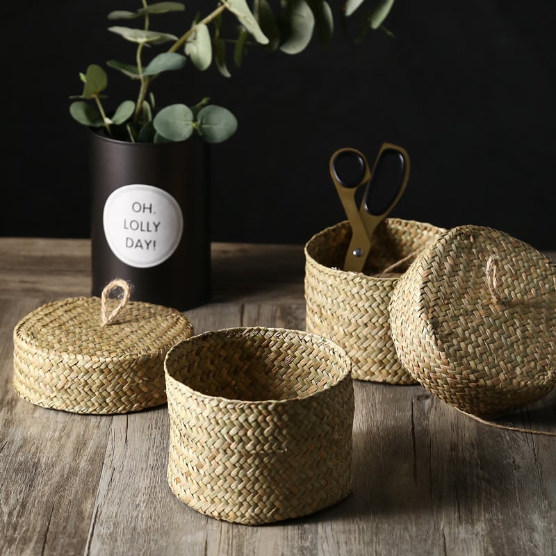 Small round woven straw basket with lid holding cosmetics
