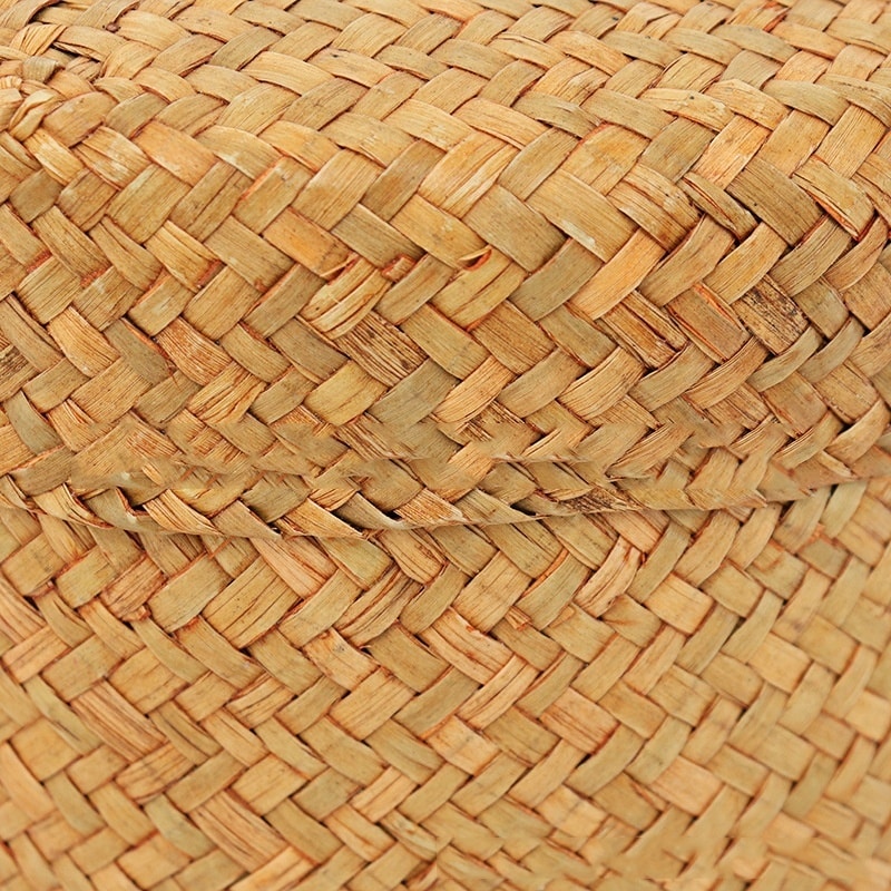 Small round woven straw basket with lid holding cosmetics