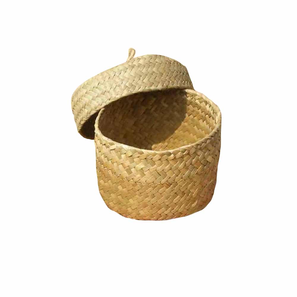 Small round woven straw basket with lid holding cosmetics