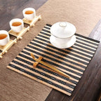 Small rectangular hand woven bamboo placemat in beige and black tones