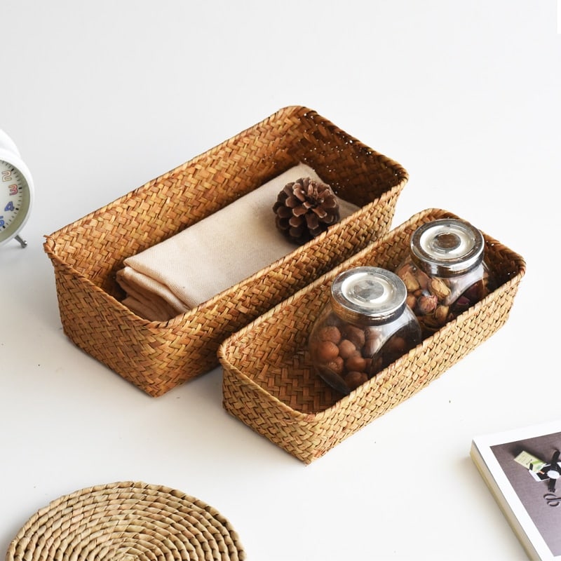 Small narrow rectangular woven baskets holding napkins and jars