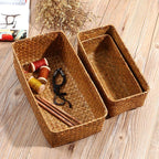 Small narrow rectangular woven baskets holding napkins and jars