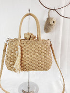 Small round hand woven rattan handbag with a double top handle and removable strap