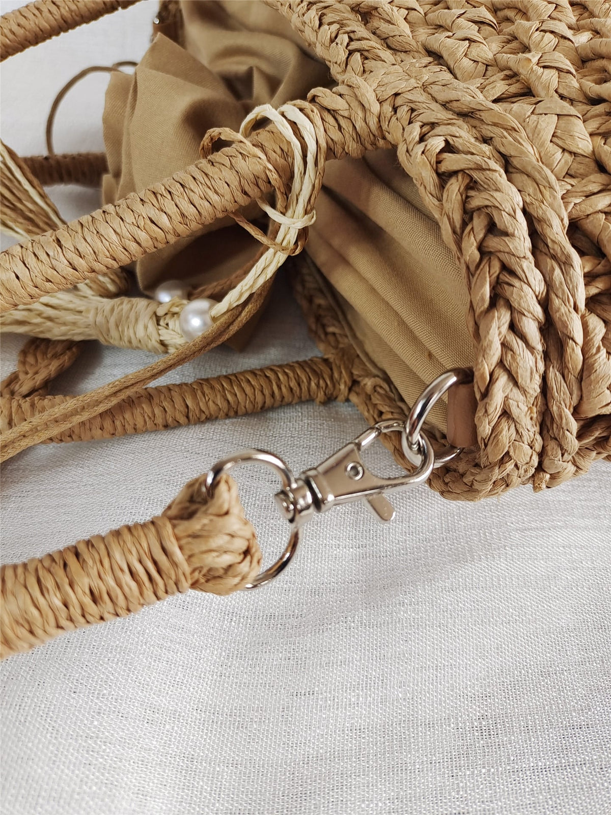 Small round hand woven rattan handbag with a double top handle and removable strap