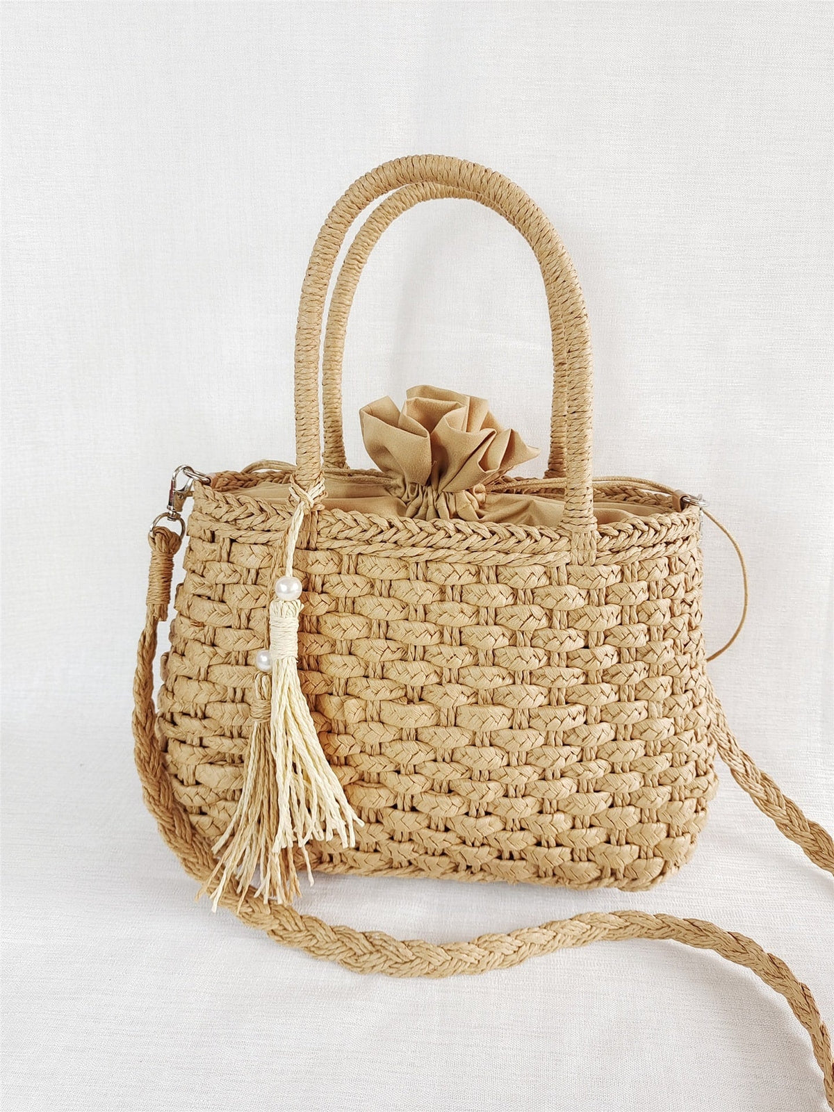 Small round hand woven rattan handbag with a double top handle and removable strap