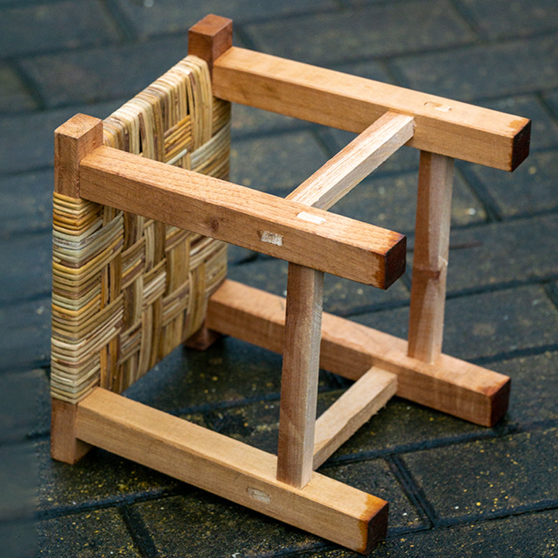 Small square stool with a multi tone woven top on a solid wood frame