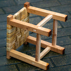 Small square stool with a multi tone woven top on a solid wood frame