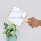 Square hand mirror with light wood frame and handle