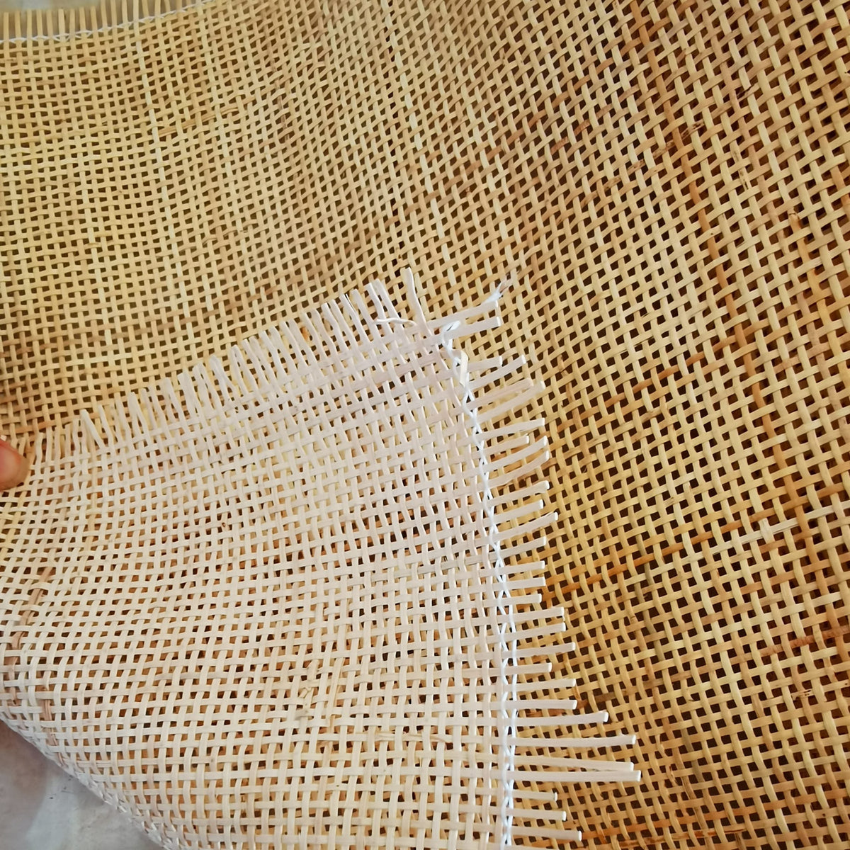 Roll of natural rattan cane webbing with a square open mesh