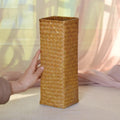 Square woven bamboo vase holding pampas grass