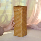 Square woven bamboo vase holding pampas grass