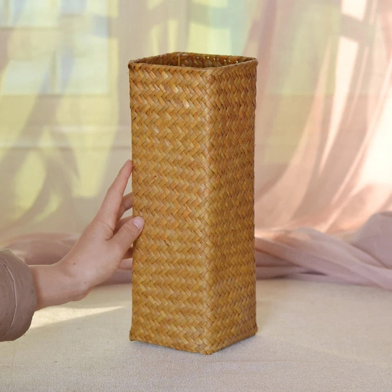 Square woven bamboo vase holding pampas grass