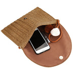 Square woven clutch with a contrasting geometric pattern and a wrist strap