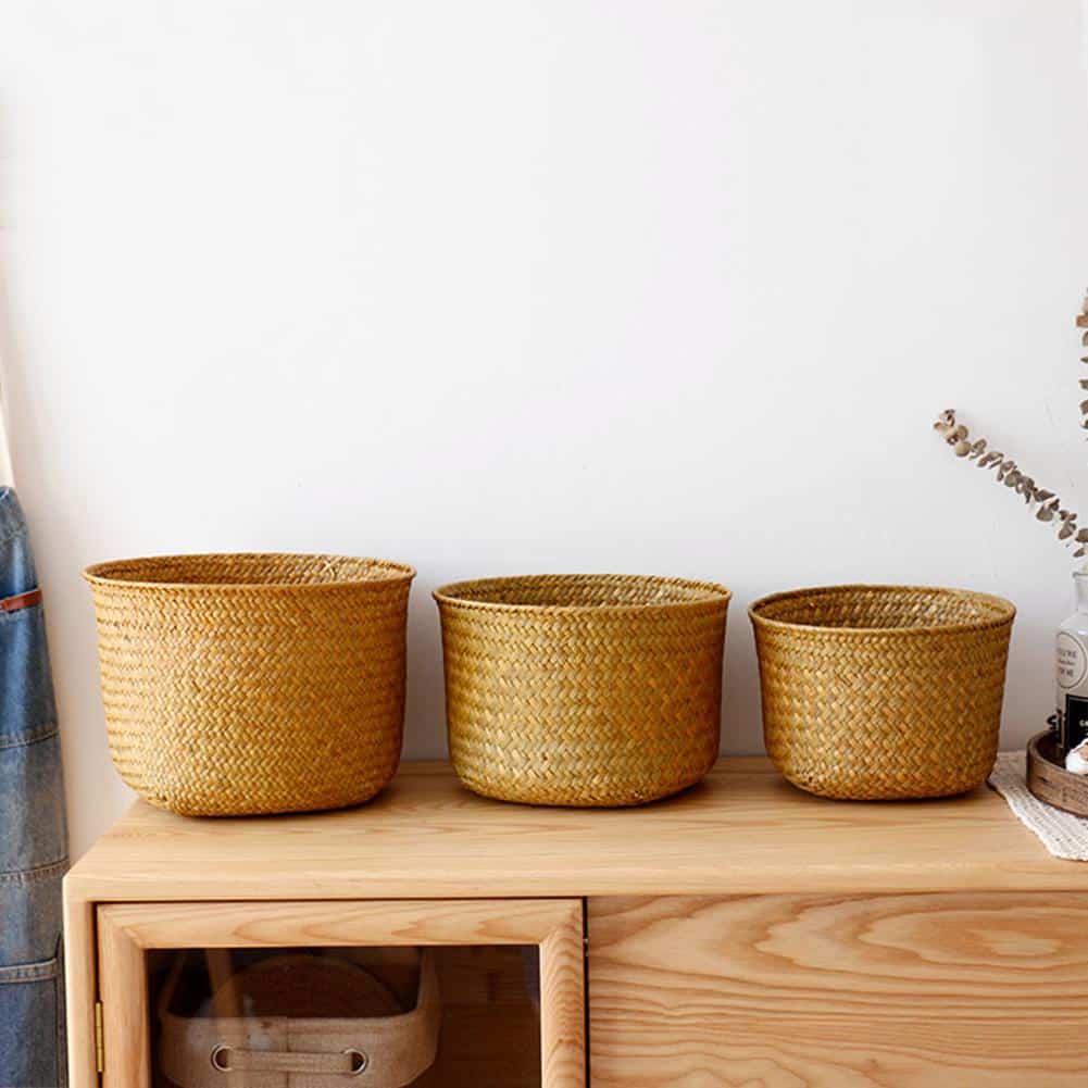 Three straight sided woven cylinder baskets on a shelf