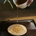 Round tightly woven rattan coaster in a warm honey brown