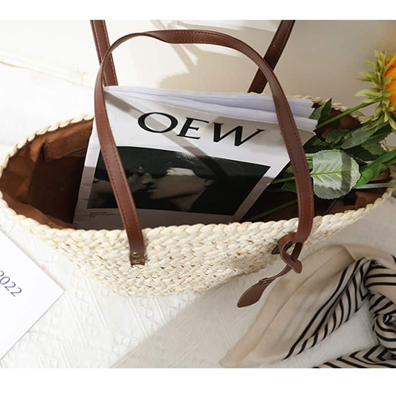 Sand toned woven straw tote with two brown knotted handles