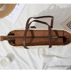 Sand toned woven straw tote with two brown knotted handles