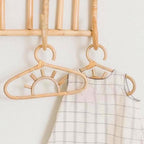 Kids' clothes hanger hand woven in natural rattan in a sun shape