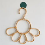 Kids' clothes hanger hand woven in natural rattan in a sunflower shape
