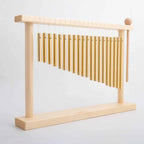 Tabletop bar chime with golden metal tubes on a bamboo wood stand