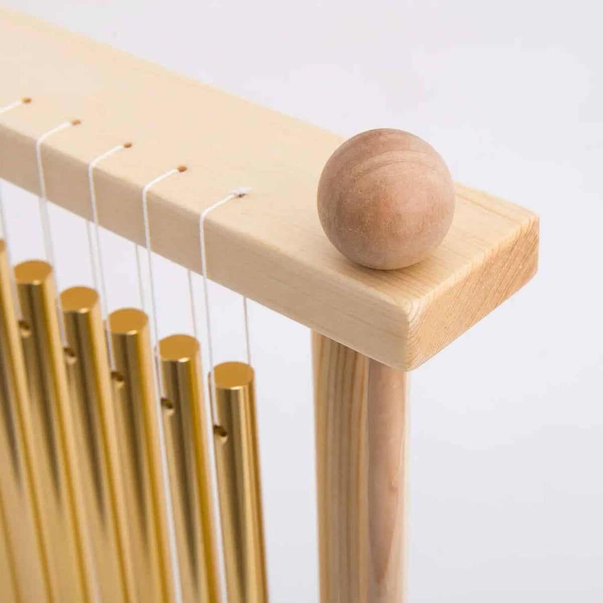 Tabletop bar chime with golden metal tubes on a bamboo wood stand