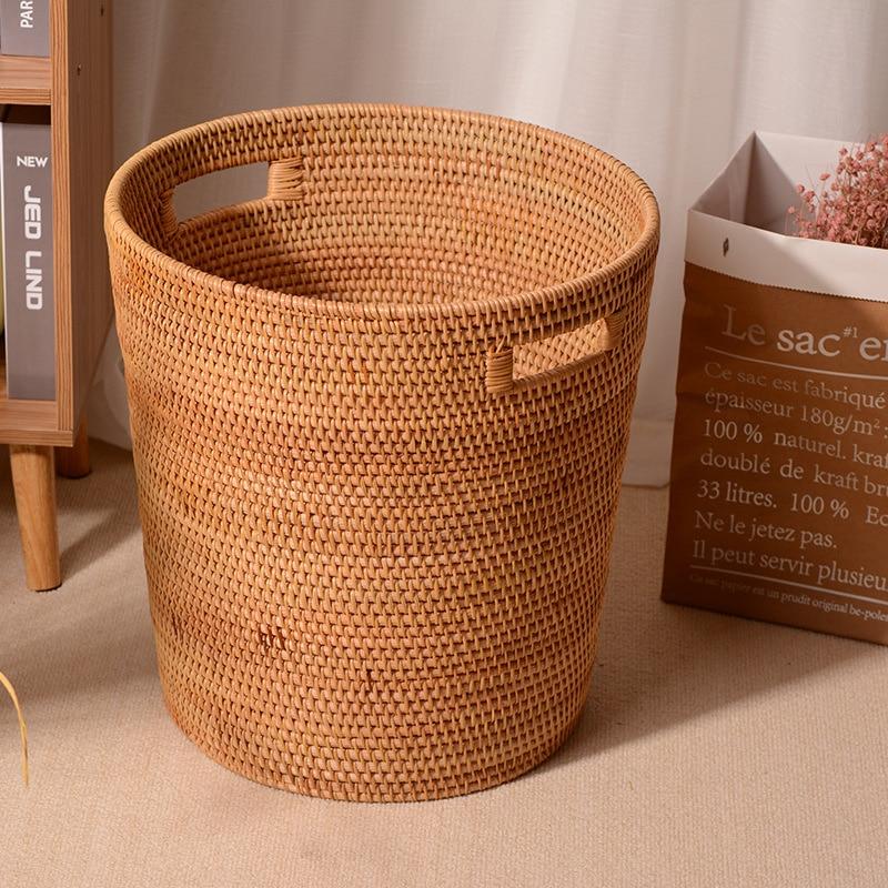 Tall honey rattan laundry basket with a towel draped over the rim