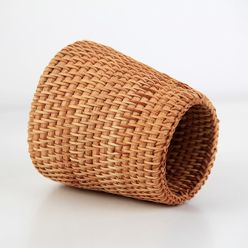 Small tapered woven rattan basket holding dried flowers