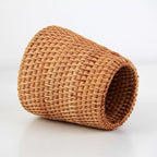 Small tapered woven rattan basket holding dried flowers