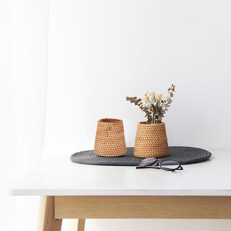 Small tapered woven rattan basket holding dried flowers