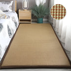 Synthetic rattan rug with a brown border beside a bed